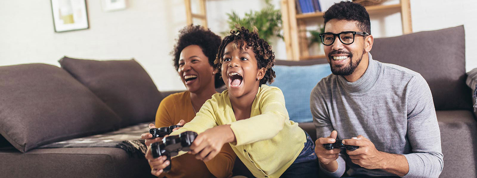 Child and parents playing video game in living room