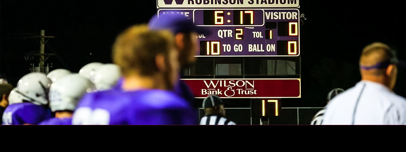 A high school football score board with Wilson bank logo.