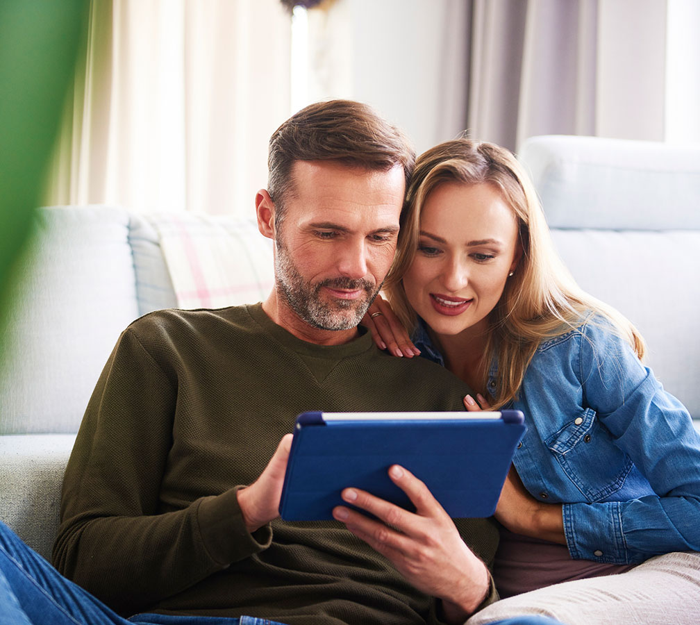Couple looking at tablet in living room