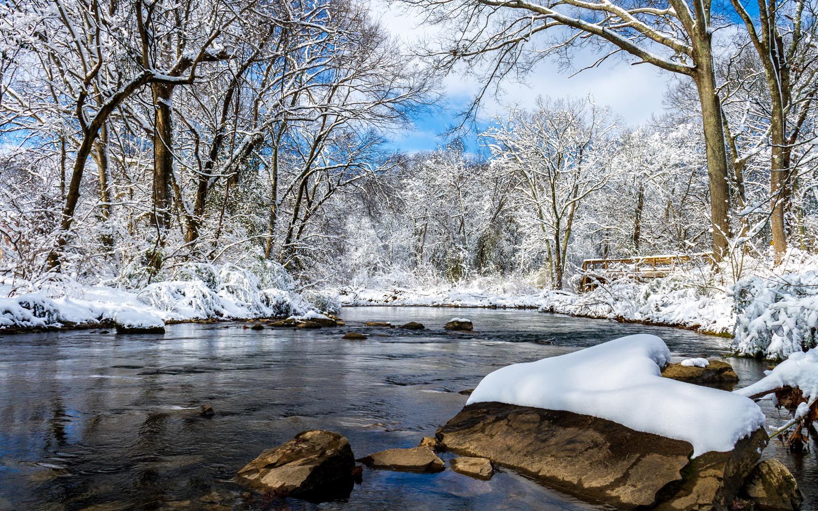 Image of TN creek in winter, blue skies, snow on rocks and banks of creek.