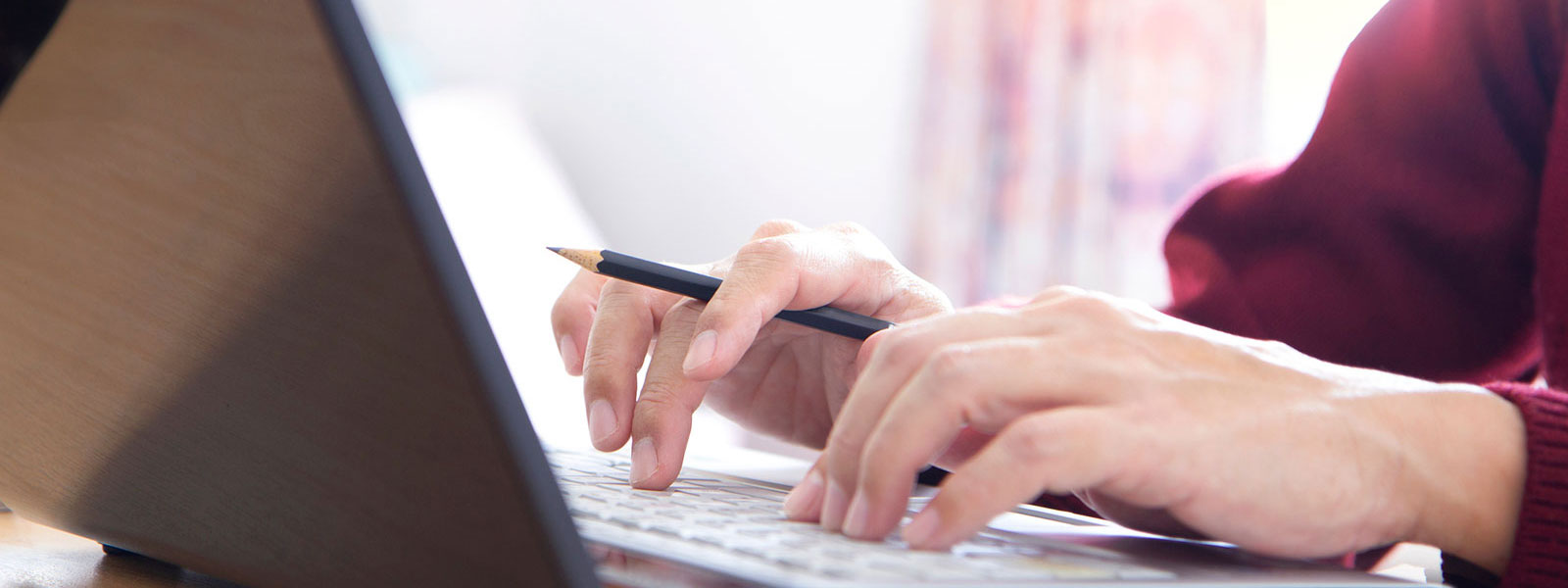 Close up of hands typing on a laptop