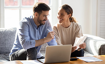 Young couple using laptop in living room