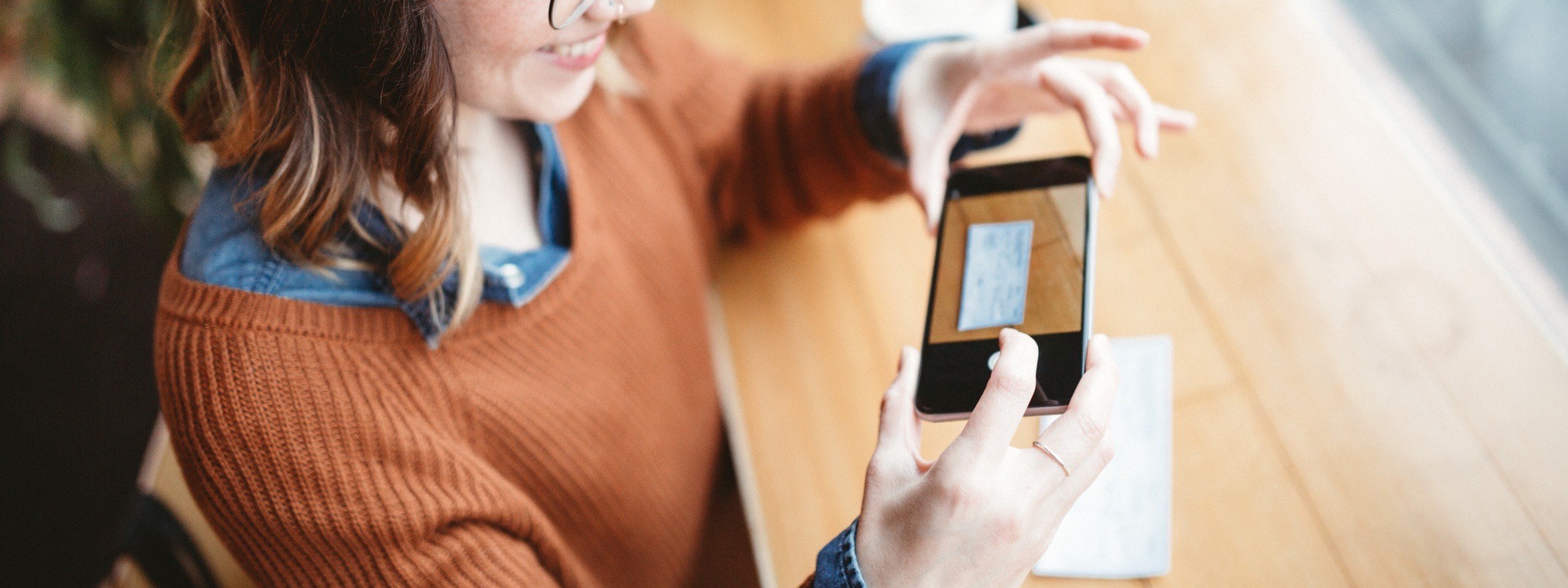 A woman takes a picture of a check for remote deposit