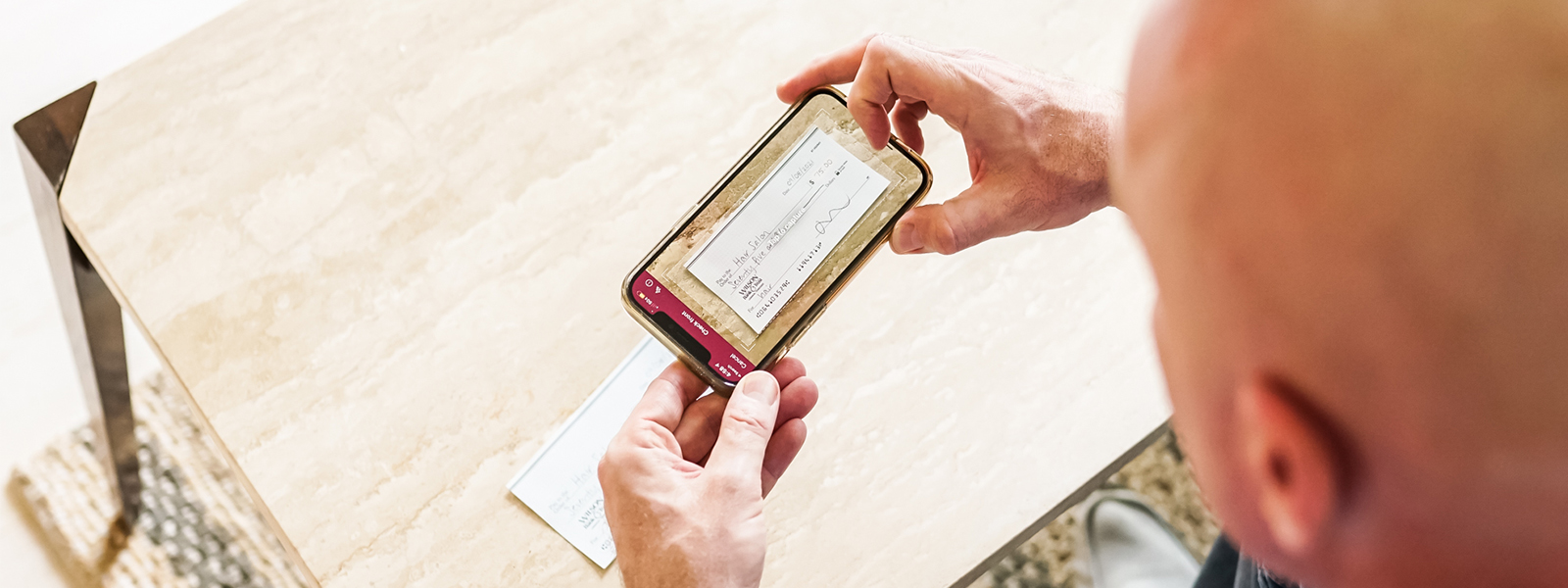 A man takes a picture of his check for mobile deposit