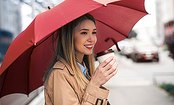 Young woman using umbrella in downtown area