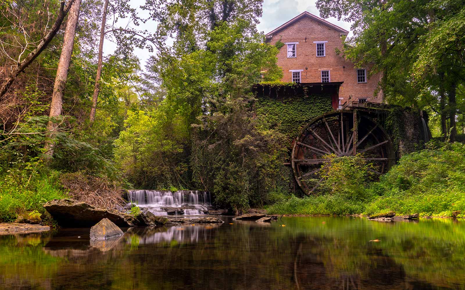 Creek with small waterfall and water mill.