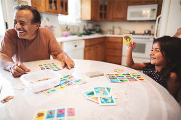 Father and daughter playing with flashcards at kitchen table